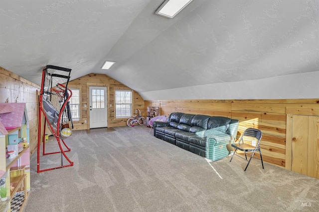 bonus room featuring lofted ceiling, wood walls, carpet flooring, and a textured ceiling