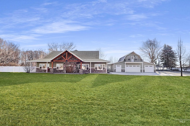 view of front of house featuring concrete driveway, an outbuilding, fence, a porch, and a front yard