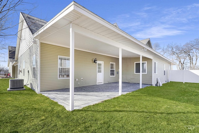 back of house featuring an attached carport, a patio area, a lawn, and fence