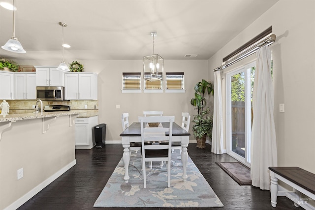 5359 N Landon Creek Pl, Meridian, ID 83646 - dining area with dark wood finished floors, baseboards, and a notable chandelier