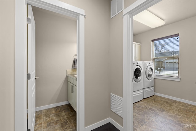 5359 N Landon Creek Pl, Meridian, ID 83646 - clothes washing area with washer and dryer, visible vents, stone finish flooring, and cabinet space