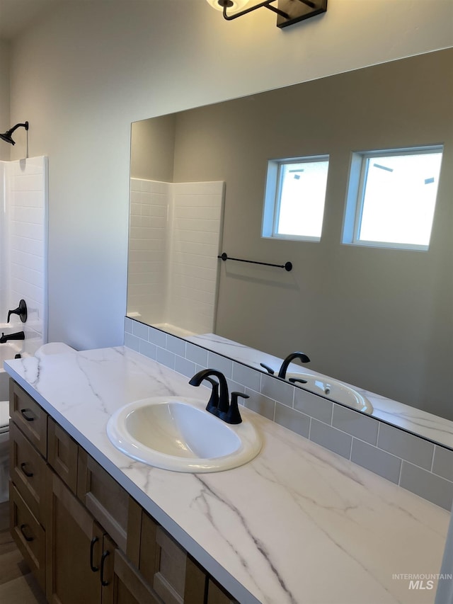 bathroom featuring toilet, walk in shower, and vanity