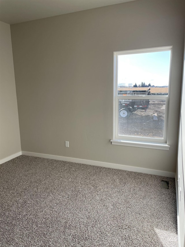 unfurnished room with carpet floors, plenty of natural light, and baseboards