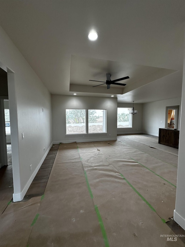 941 Gregory Way, Twin Falls, ID 83301 - unfurnished living room featuring a tray ceiling, baseboards, ceiling fan, recessed lighting, and a chandelier