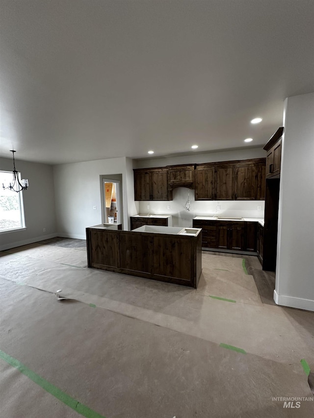 941 Gregory Way, Twin Falls, ID 83301 - kitchen featuring concrete flooring, dark brown cabinets, a kitchen island, a chandelier, and recessed lighting