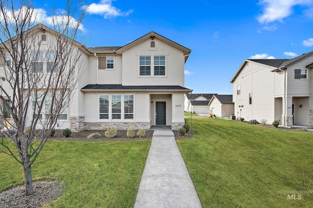 view of front of house with a front yard, stone siding, and stucco siding