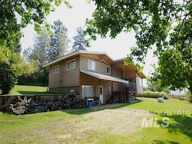 rear view of house with a lawn and a patio