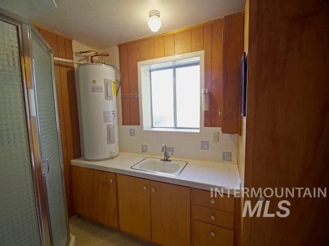 bathroom with a shower with door, vanity, electric water heater, and tasteful backsplash