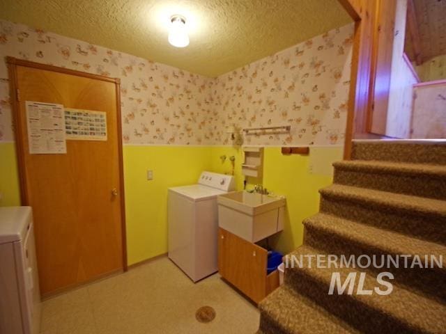 laundry room featuring independent washer and dryer and a textured ceiling