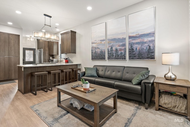 living area with light wood-style flooring and recessed lighting