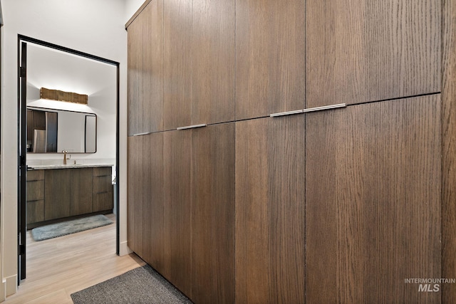 interior space featuring light countertops, light wood finished floors, modern cabinets, and a sink