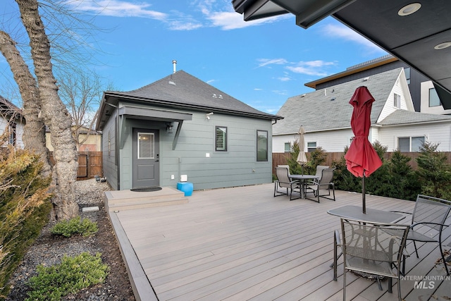 wooden terrace featuring outdoor dining area and fence