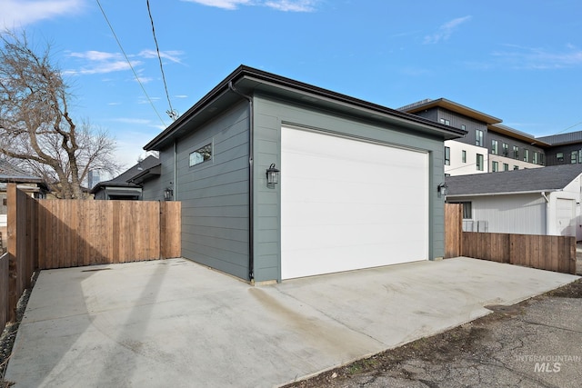 garage with driveway and fence