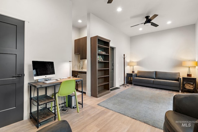 living area with light wood-style floors, a ceiling fan, and recessed lighting