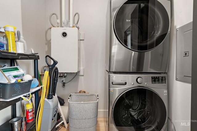 laundry area featuring stacked washing maching and dryer, water heater, and laundry area