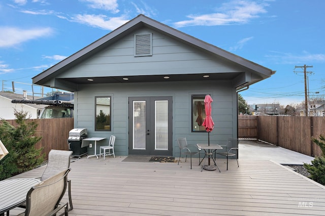 rear view of property featuring french doors, a fenced backyard, and a wooden deck