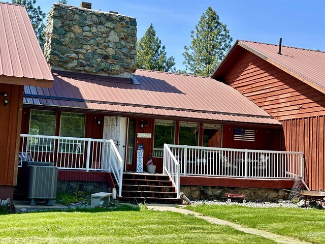 170 Red Fir, Kooskia, ID 83539 - view of front of home with a front lawn, covered porch, board and batten siding, metal roof, and central air condition unit