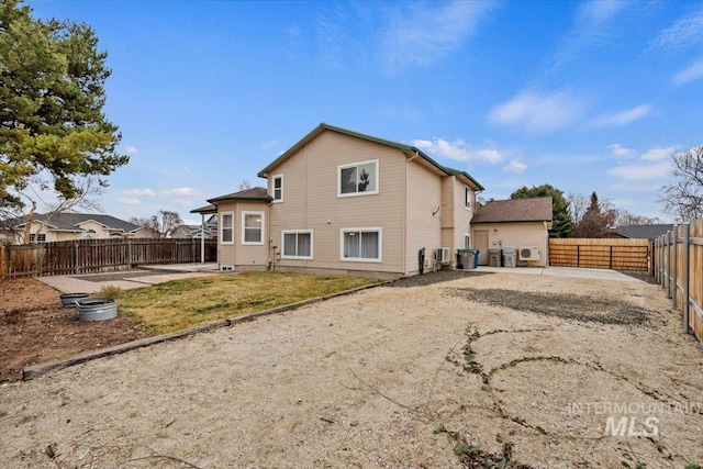 rear view of property featuring a fenced backyard and a patio