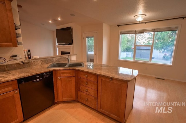 kitchen featuring light hardwood / wood-style flooring, sink, black dishwasher, kitchen peninsula, and light stone countertops