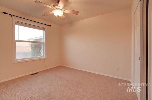 carpeted spare room with ceiling fan