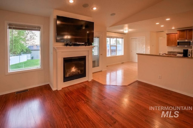 unfurnished living room with vaulted ceiling and hardwood / wood-style floors