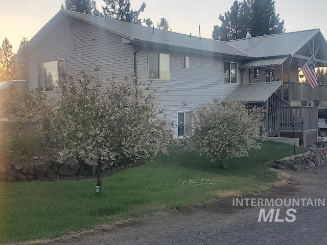 property exterior at dusk featuring a yard