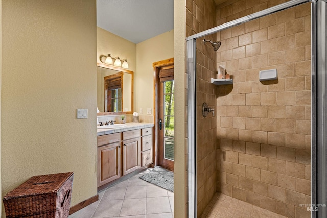 bathroom featuring tile patterned flooring, vanity, and walk in shower