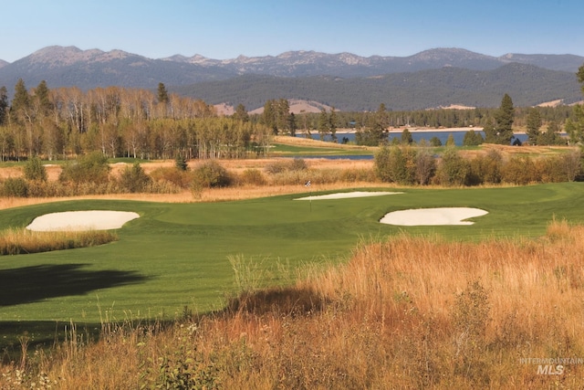 surrounding community with a mountain view and a yard