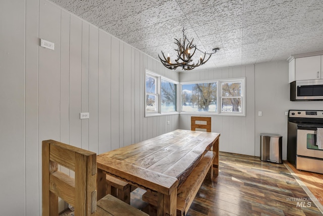 dining space with an inviting chandelier and hardwood / wood-style flooring