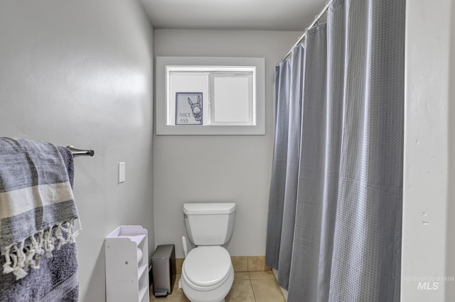 bathroom with tile patterned flooring, curtained shower, and toilet