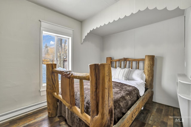 bedroom featuring a baseboard heating unit and wood finished floors