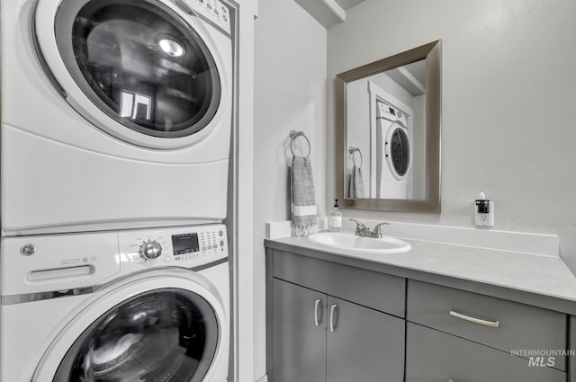 clothes washing area featuring stacked washer and clothes dryer and a sink