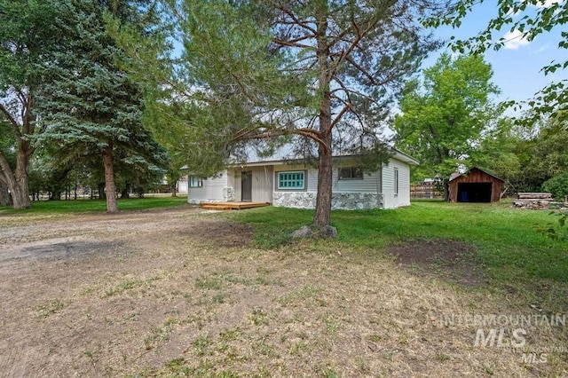 view of front of house with an outbuilding and a front lawn