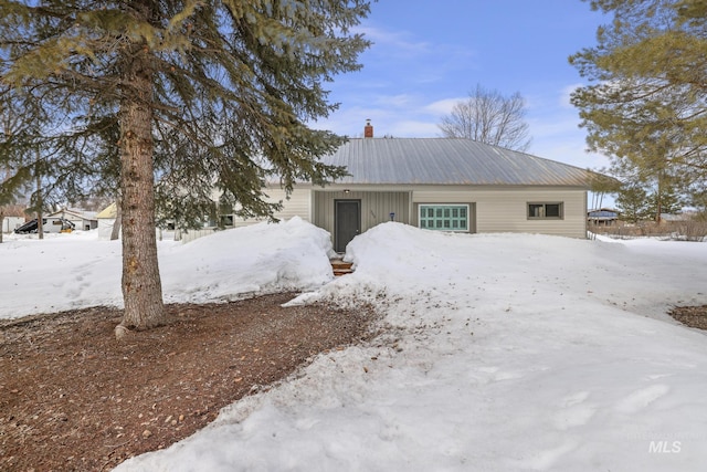 view of front of house featuring a chimney and metal roof