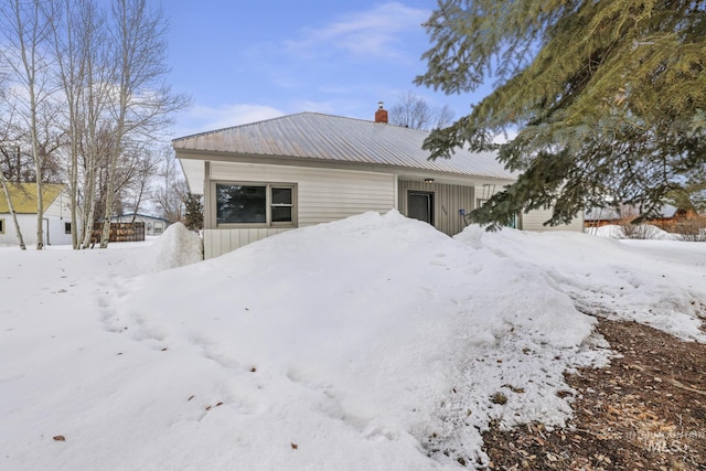 exterior space featuring metal roof and a chimney