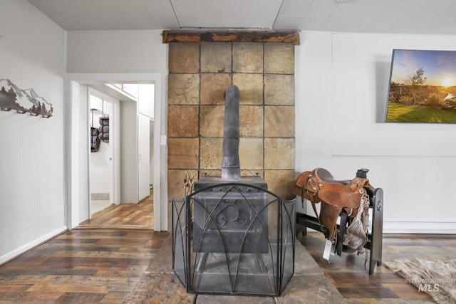 interior details featuring a wood stove and wood finished floors