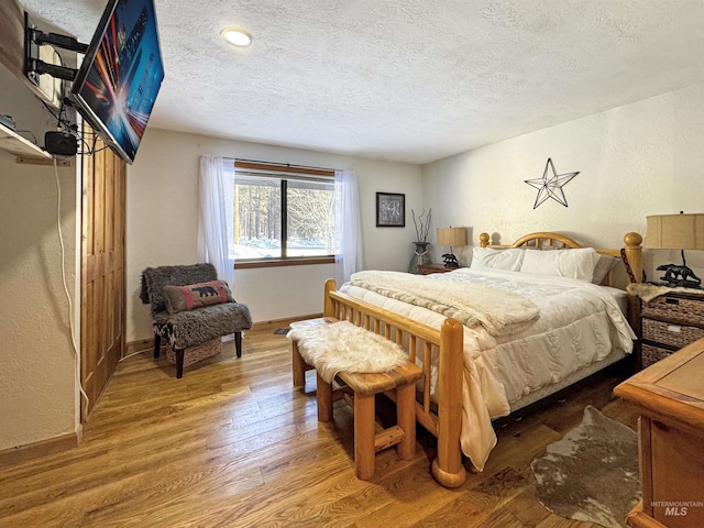 bedroom featuring hardwood / wood-style floors and a textured ceiling