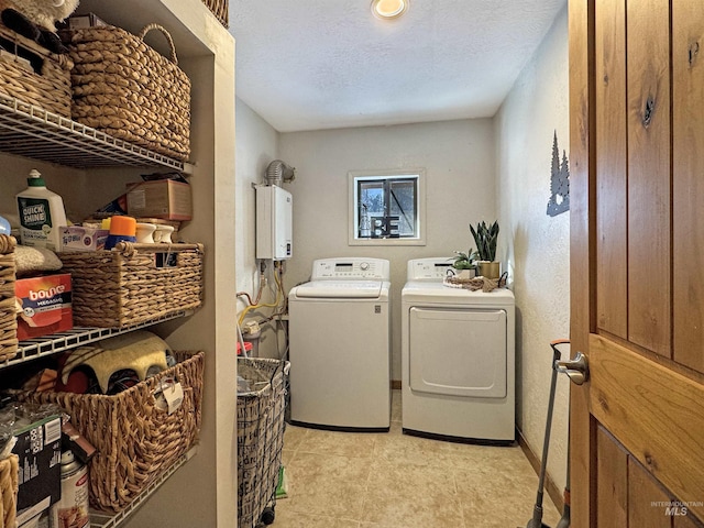 clothes washing area featuring a textured ceiling, tankless water heater, and independent washer and dryer