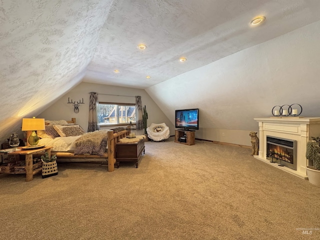 bedroom featuring carpet, vaulted ceiling, and a textured ceiling