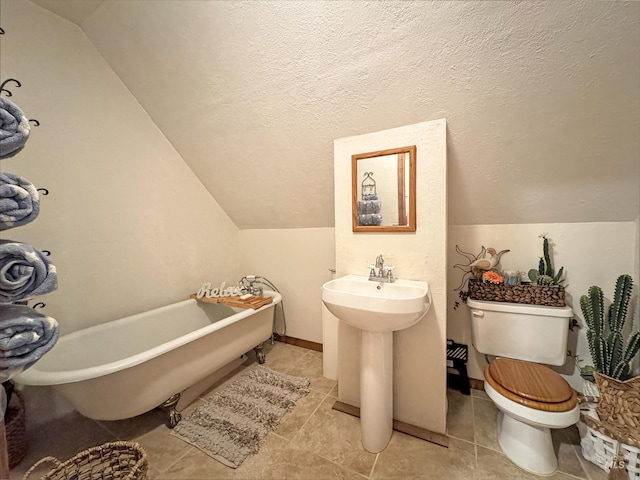 bathroom featuring toilet, vaulted ceiling, a textured ceiling, and a bath