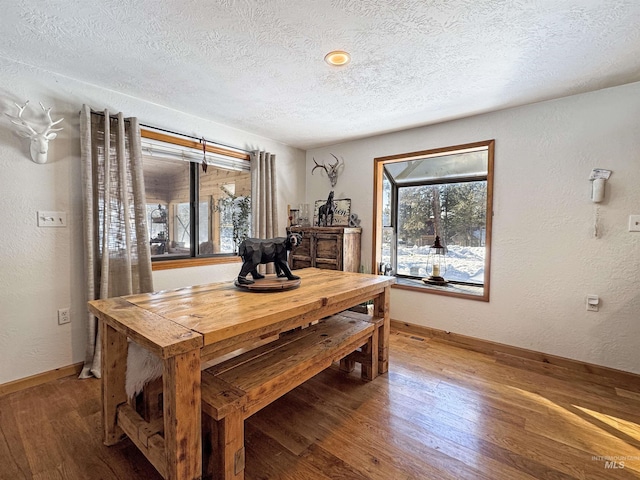 dining area featuring a textured ceiling and dark hardwood / wood-style flooring