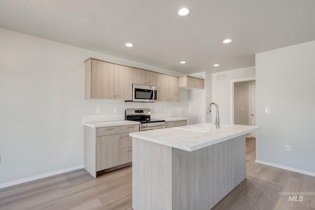 1468 N Coltsfoot Ave, Kuna, ID 83634 - kitchen featuring stainless steel appliances, a sink, light brown cabinetry, light wood finished floors, and recessed lighting