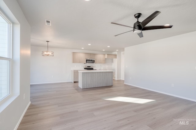 1468 N Coltsfoot Ave, Kuna, ID 83634 - unfurnished living room featuring a ceiling fan, light wood finished floors, a sink, baseboards, and recessed lighting
