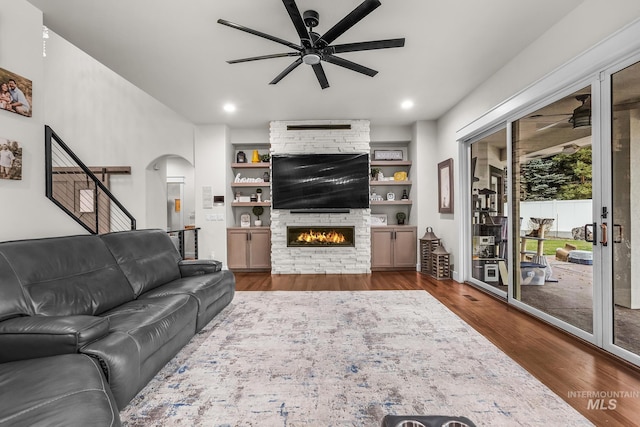 3136 S Bear Claw Way, Meridian, ID 83642 - living area featuring a ceiling fan, arched walkways, dark wood-style floors, a fireplace, and recessed lighting