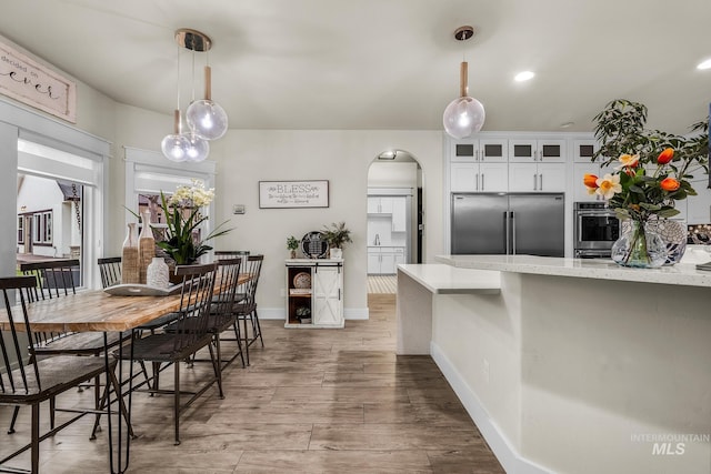 3136 S Bear Claw Way, Meridian, ID 83642 - dining room featuring arched walkways, wood finished floors, and baseboards