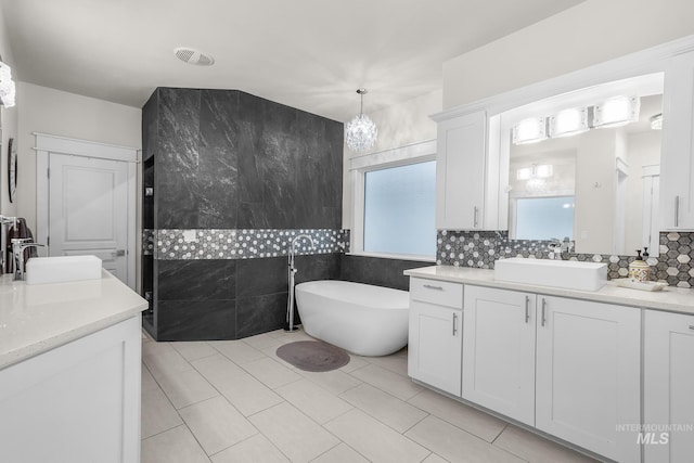 3136 S Bear Claw Way, Meridian, ID 83642 - bathroom with two vanities, a soaking tub, backsplash, and tile patterned floors