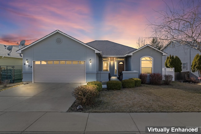 ranch-style house featuring a garage, roof with shingles, and driveway