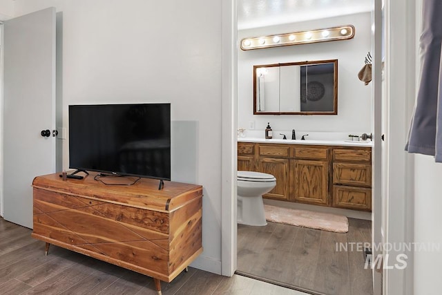 bathroom featuring vanity, hardwood / wood-style flooring, and toilet