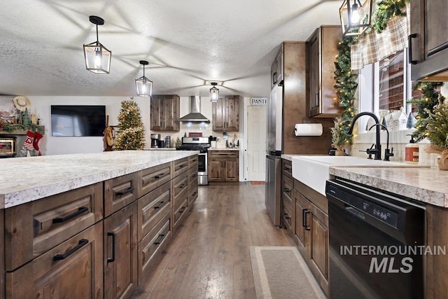 kitchen with wall chimney exhaust hood, wood-type flooring, dark brown cabinetry, and appliances with stainless steel finishes