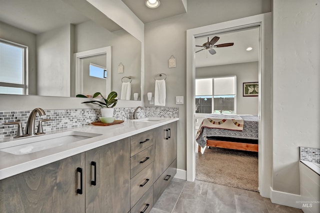 bathroom with ceiling fan, vanity, and backsplash